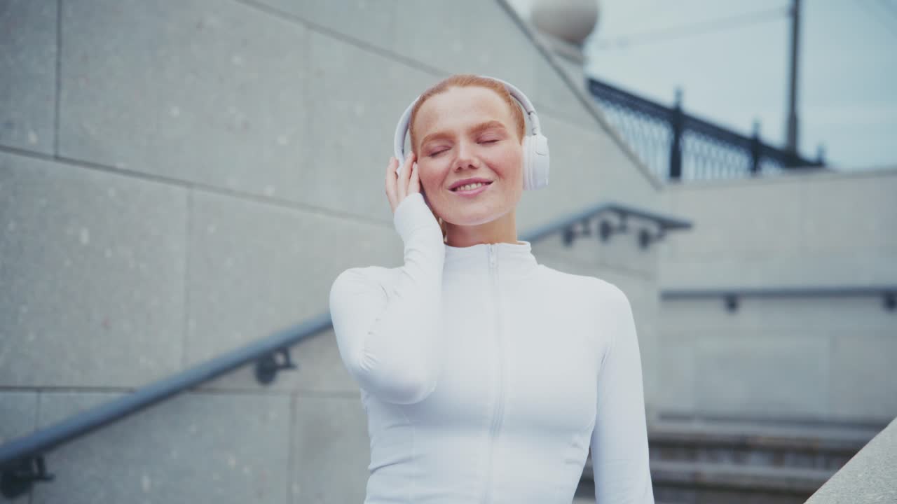Woman listening to music on headphones outdoors