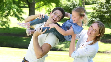 padres felices con su niña en el parque
