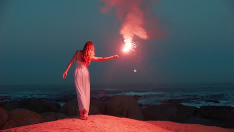 Frau-Winkt-Im-Morgengrauen-Am-Strand-Mit-Fackel-Und-Brennt-Das-Signal-Des-Frühen-Morgens