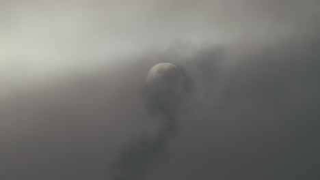 a misty morning sun is getting covered by dark smoke.
