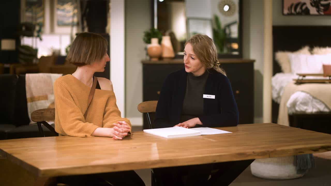A Female Furniture Sales Person Closes a Deal with Customer at a Table