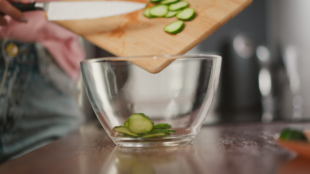 Woman chopping cucumbers for a salad