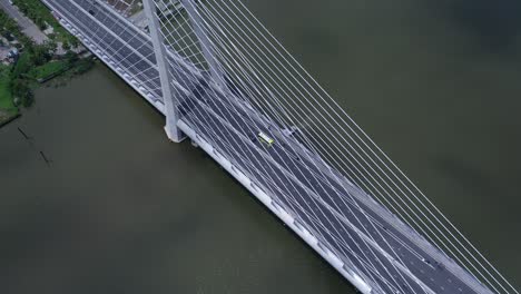 aerial orbit view of suspension bridge over river with road traffic