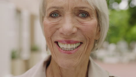 close up portrait of elegant elderly woman smiling happy looking at camera enjoying retirement urban city background