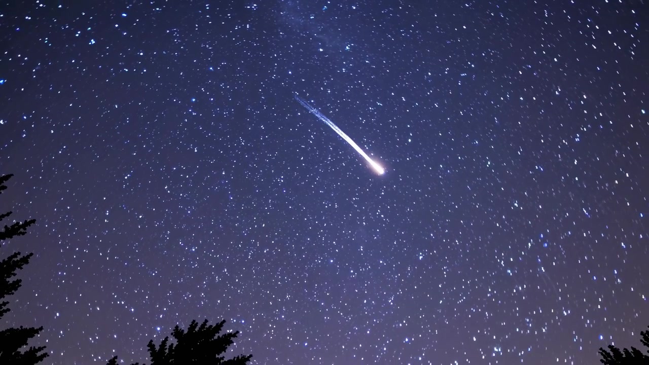 Bright Meteor Streaking Across Starry Night Sky