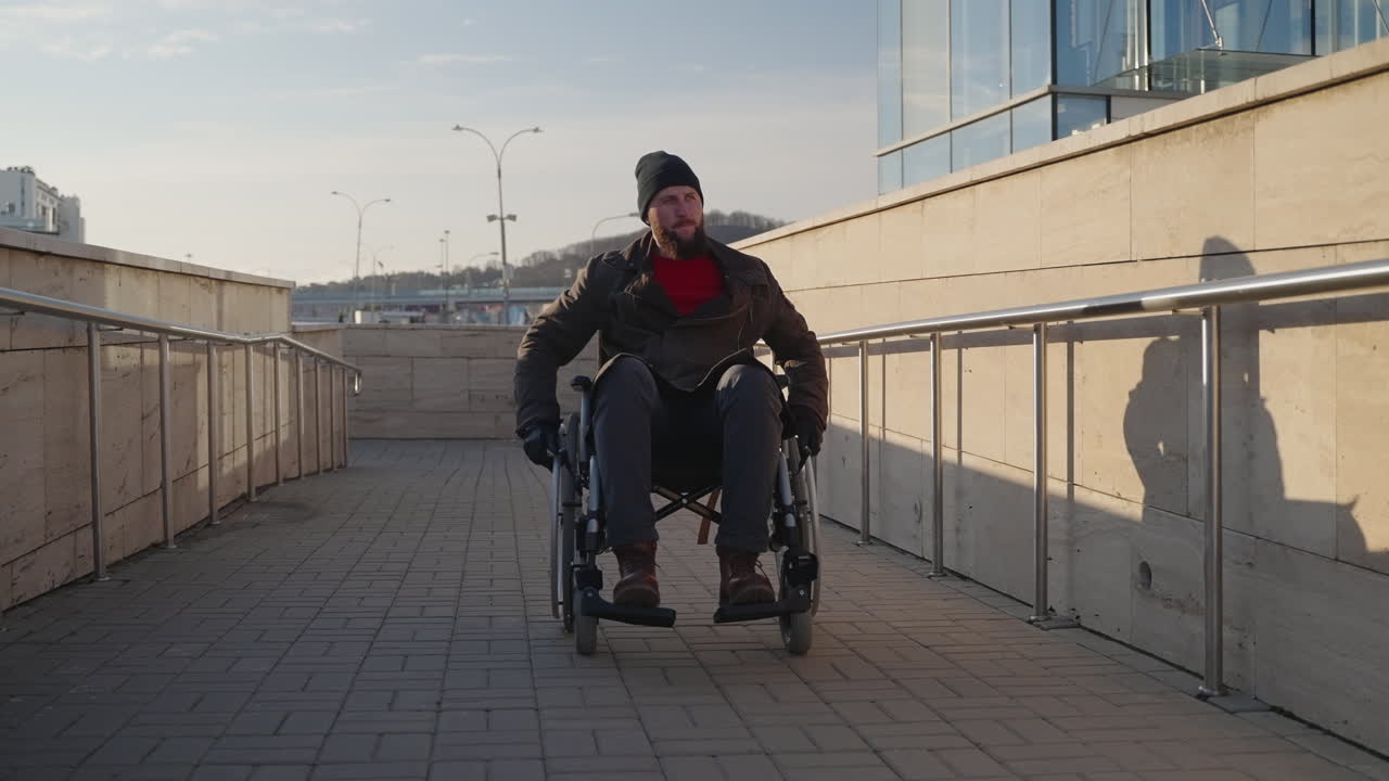 hombre en silla de ruedas en la rampa de la ciudad