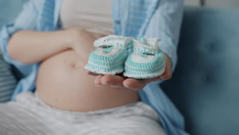 pregnant woman holding baby booties