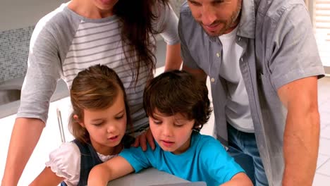 familia usando computadora portátil en la cocina