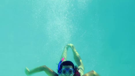 pretty brunette diving into swimming pool wearing snorkel