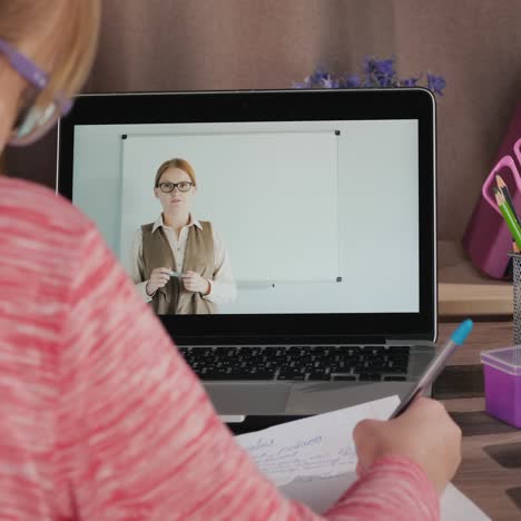 girl does lessons near laptop classes online during quarantine and self-isolation