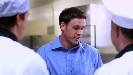 Handsome-waiter-talking-with-the-chefs