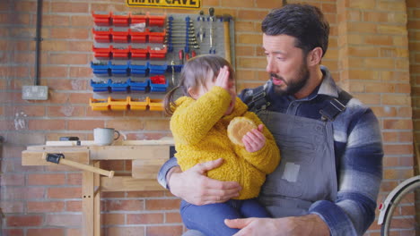 father with down syndrome daughter eating cake in home workshop