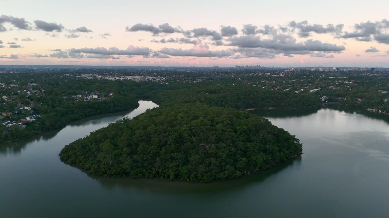 Calm inlet at Lime Kiln Head Oatley surrounded by trees and sky reflecting on water surface, aerial establishing orbit