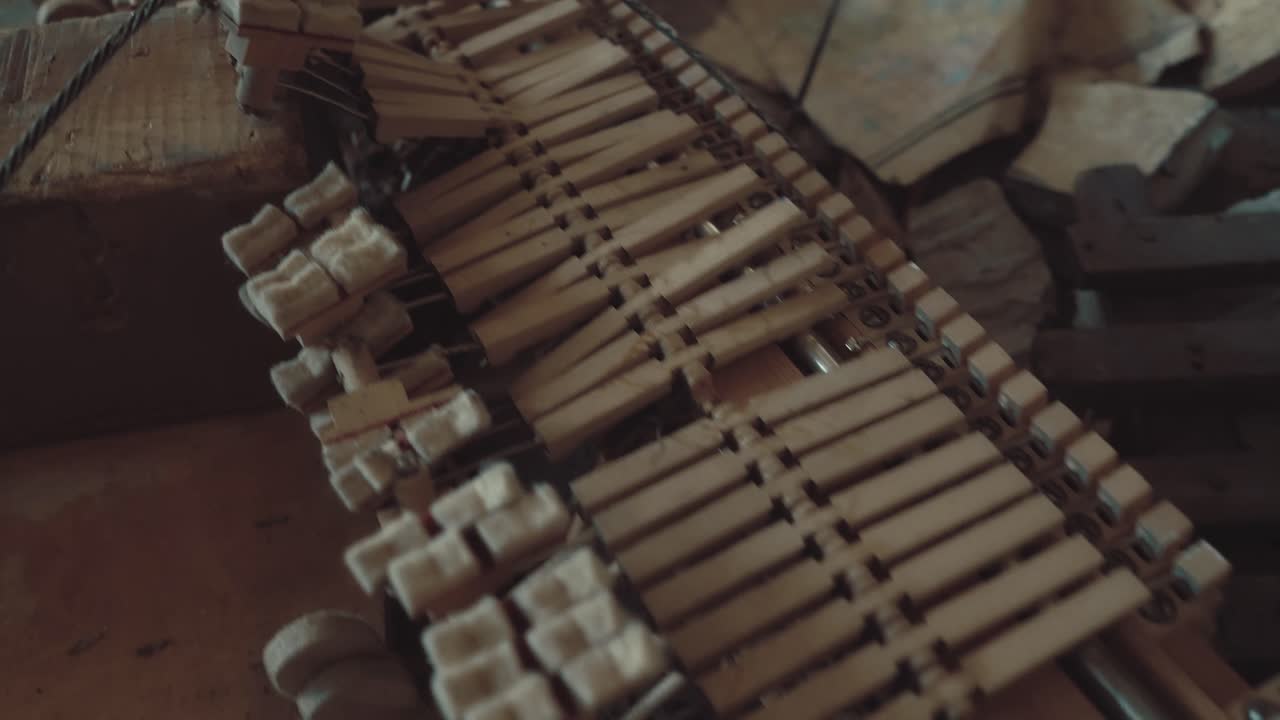 Broken parts of a piano lie in a ruined building amidst garbage