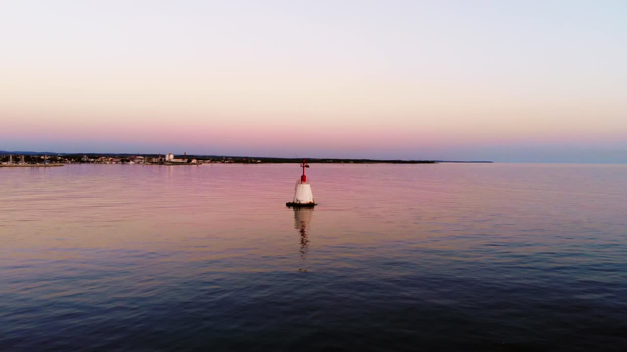 산호초를 표시하는 빨간 부표가 있는 잔잔한 바다 위로 평화로운 일몰