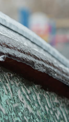 primer plano de la ventana de un coche helado con hielo derretido, fondo colorido borroso, destacando los contrastes de textura y el frío vívido del paisaje invernal