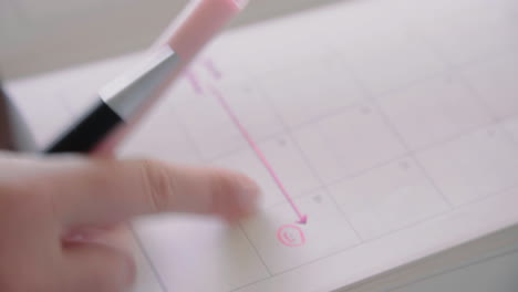 Young-female-pointing-on-a-smiley-in-her-calendar-notebook-memo-where-she-achieves-a-certain-goal-in-time-4K-Close-Up