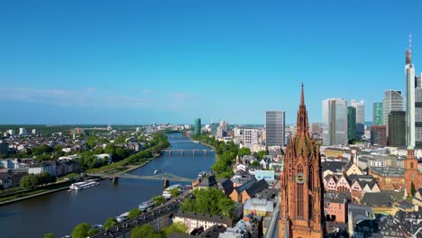 4k aerial drone video of the kaiserdom st. bartholomäus church on the banks of the main river in downtown frankfurt, germany