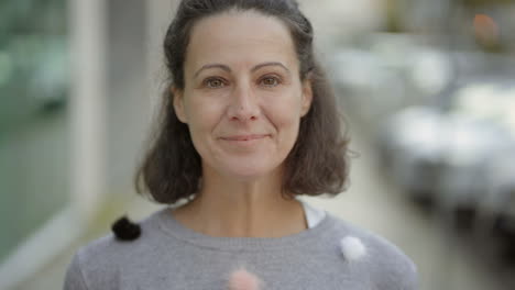 beautiful middle aged woman looking at camera and laughing.