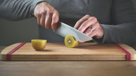 primer plano del hombre cortando kiwi