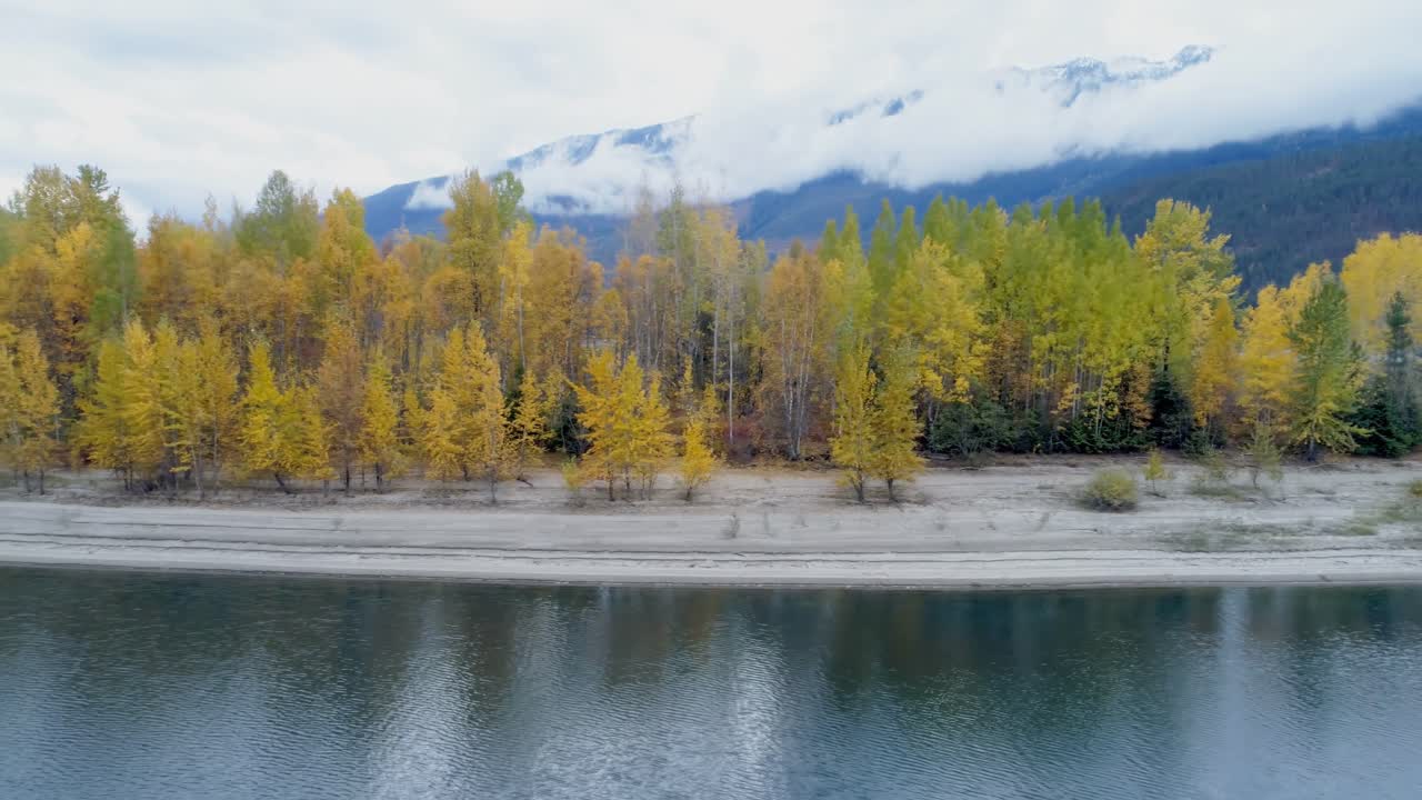 Foresta autunnale e catene montuose lungo il lago 4k