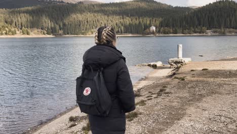 bolboci, romania - a lady leisurely walking beside the lake - tracking shot