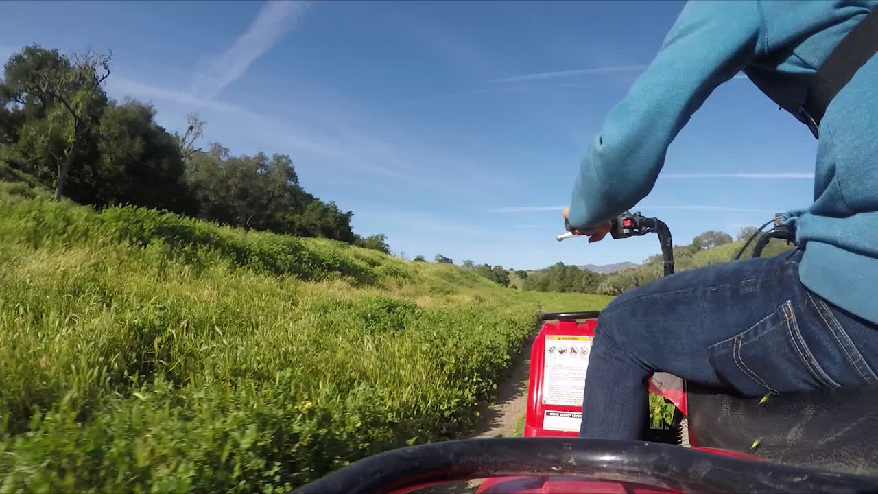tiro gopro de atv timelapse cabalgando sobre un camino de tierra en los campos verdes de california