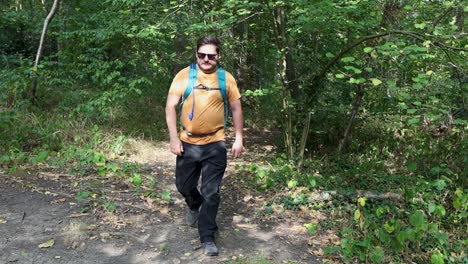 Junger-Mann-Mit-Rucksack-Und-Sonnenbrille-Kommt-Aus-Dem-Wald-Und-überprüft-Sein-Handy