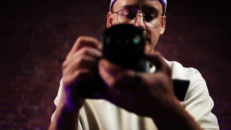 Low-angle-approach-toward-photographer-sit-and-hold-digital-camera-at-studio