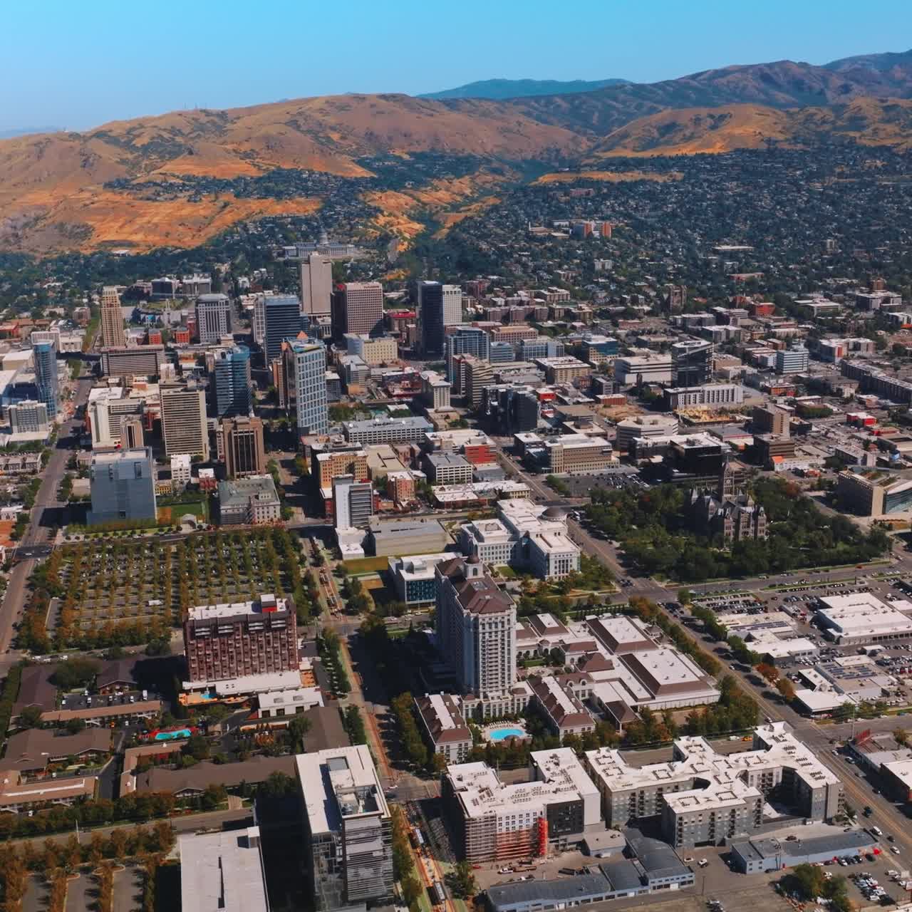 Amazing city scenery limited by mountains behind. Gorgeous view of Salt Lake City, Utah, USA on sunny day from aerial view