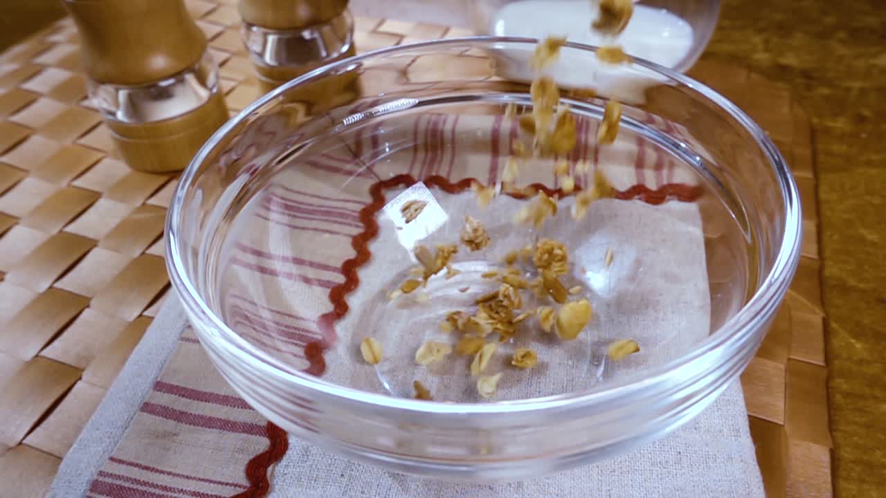 아침에 우유와 함께 맛있는 아침 식사를 위해 그 ⁇ 에 온밀 곡물 무슬리. 회전 추적 촬영과 함께 느린 동작.