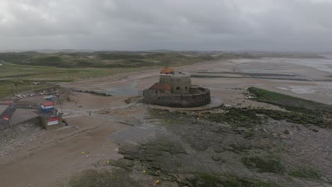 drone flying away from a historical fort revealing the coastal village ambleteuse in france