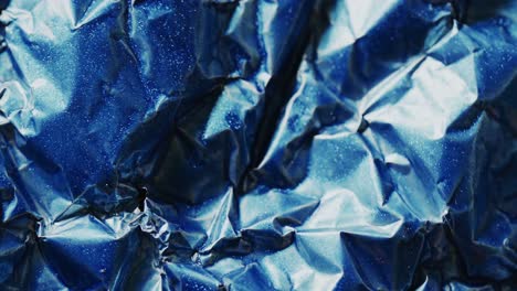 Close-up-of-blue-crumpled-piece-of-paper-in-slow-motion