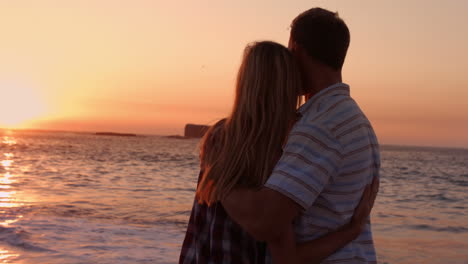 Linda-Pareja-Abrazándose-Durante-La-Puesta-De-Sol-En-La-Playa