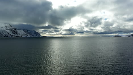 vuelo sobre el océano tranquilo al amanecer durante el invierno en las islas lofoten, noruega