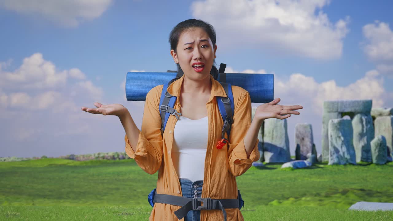 Puzzled Asian Female Hiker With Mountaineering Backpack Making Gestures Doubtfully And Saying Why While Traveling In Stonehenge