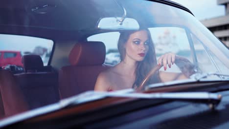 una mujer conduciendo un coche de época.