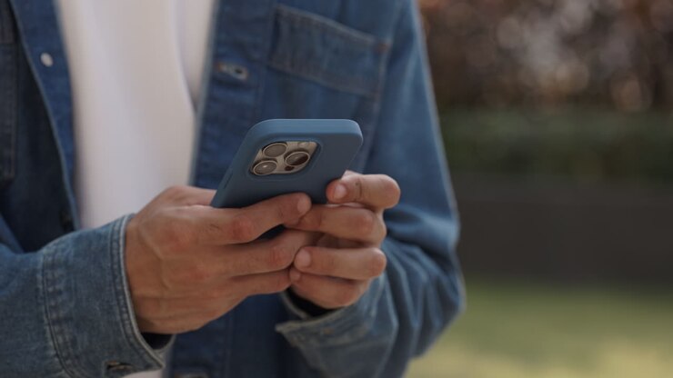 Close-up of Person's Hands Typing on Smartphone Outdoors