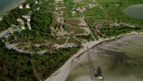 Birds-eye-view-as-4K-drone-gracefully-rotates,-revealing-lush-tropical-trees-and-pristine-beaches