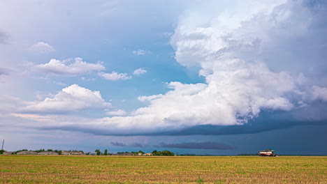 Powerful-rain-clouds-forming-storm-above-rural-landscape,-time-lapse
