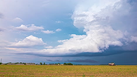 powerful rain clouds forming storm above rural landscape, time lapse