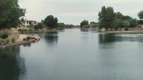 Aerial-drone-shot-flying-out-over-a-community-lake-on-a-cloudy-day