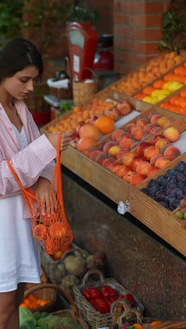 mujer comprando frutas frescas en una tienda de comestibles