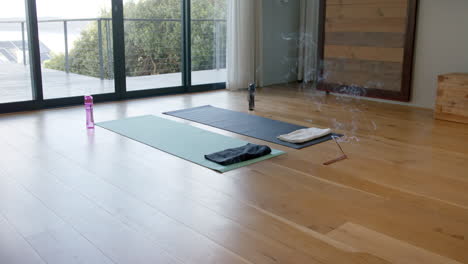 yoga mats, water bottles and incense on floor, slow motion