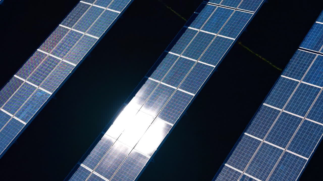Vista dall'alto di pannelli solari con riflesso centrale del sole. Inquadratura dall'alto di pannelli fotovoltaici blu con riflesso solare brillante e ombre scure tra le file