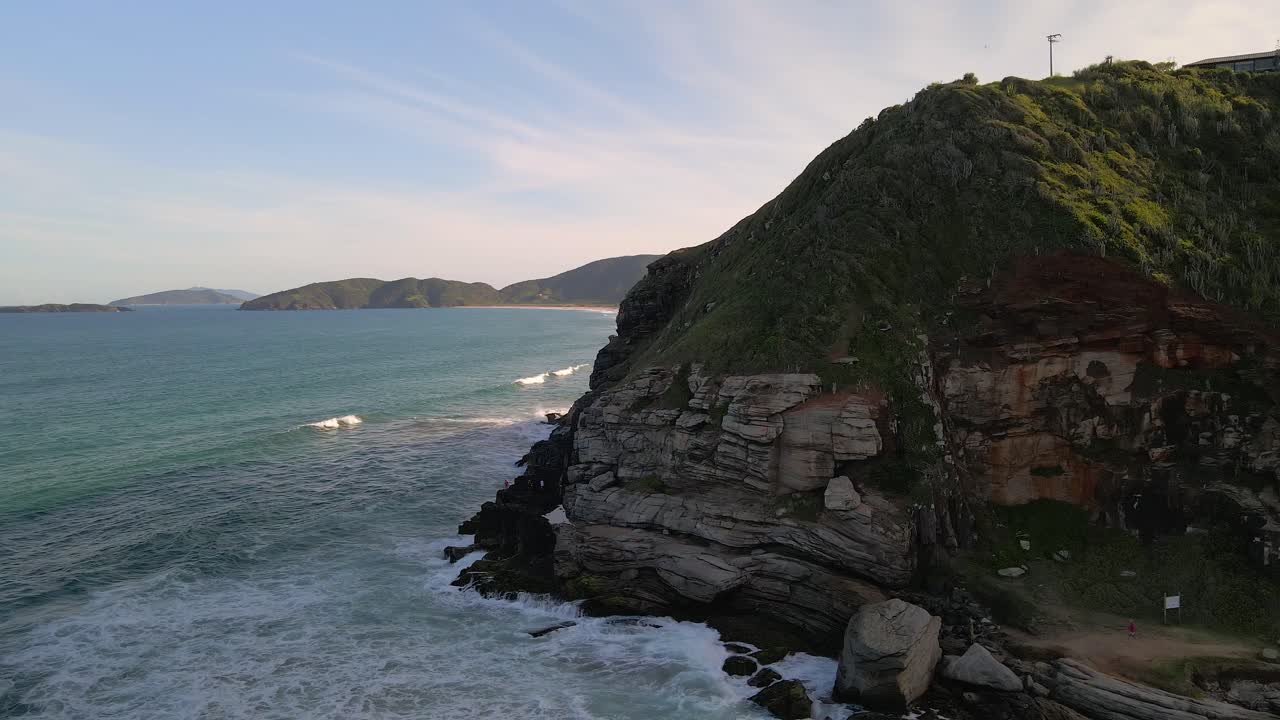 Flying by ocean cliff, waves splashing aganst rocks, Brazil shoreline