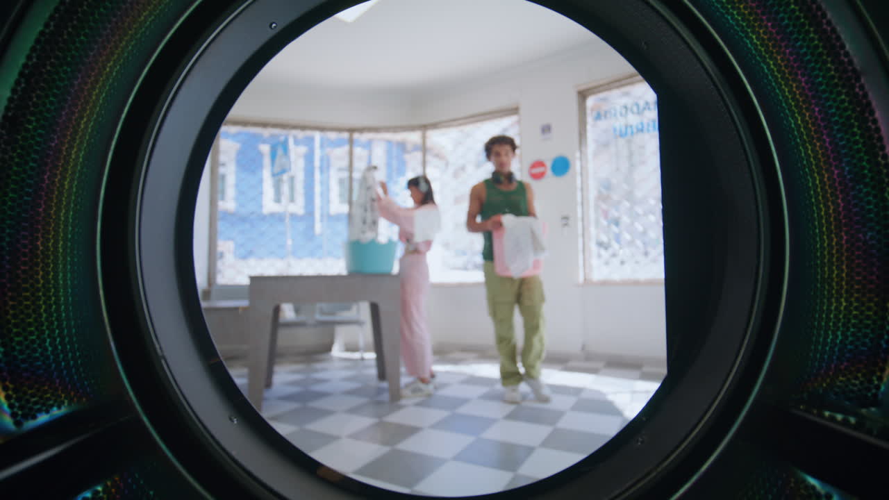 도시에서 세탁실을 이용하는 사람들. 클로즈업 젊은 남자가 옷을 고 있다.