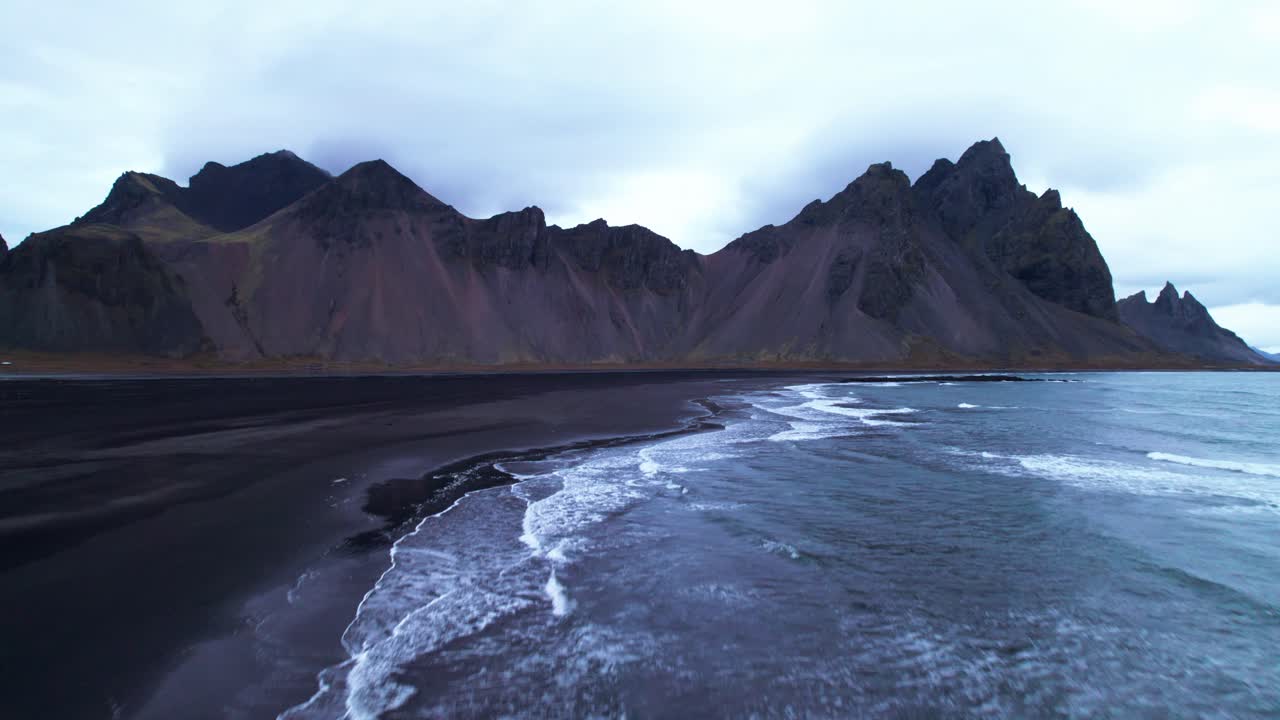 공중에서: 베스트라호른, 그 상징적인  ⁇ 은 꼭대기와  ⁇ 아오르는 기둥으로, 이 어두운 광야에서 거대한 돌 성당처럼 극적으로 올라갑니다.