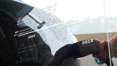 charging electric vehicle with animation of futuristic data overlay in rain