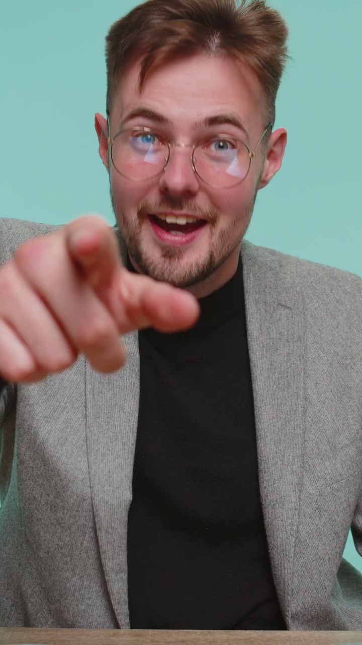 Forretningsmand smiler, peger mod kameraet, vælger en heldig vinder og præsenterer en fantastisk kampagne til dig